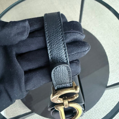 Sac Dior Saddle Small 21 cm en cuir caviar noir avec bandoulière et finitions dorées.