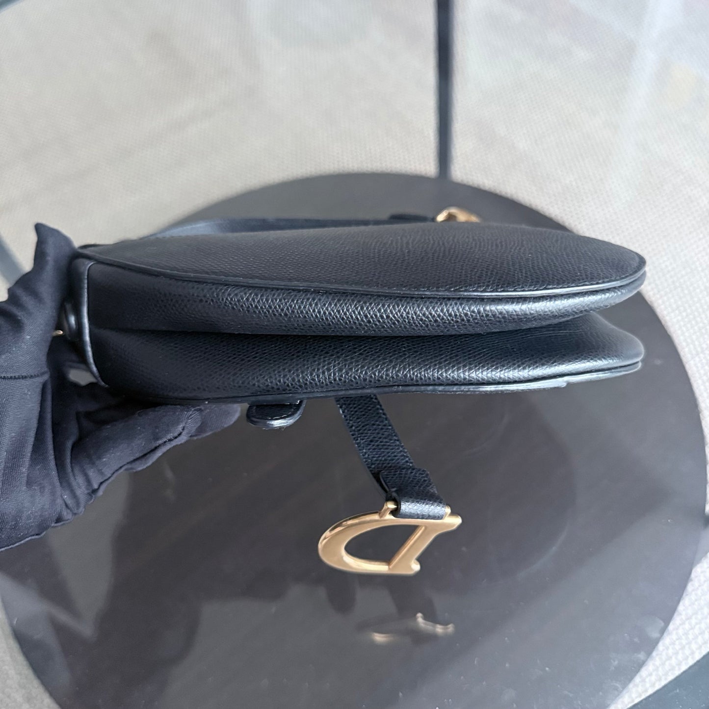Sac Dior Saddle Small 21 cm en cuir caviar noir avec bandoulière et finitions dorées.