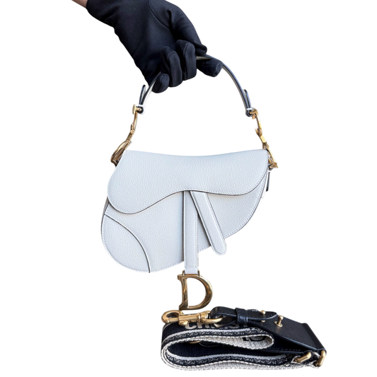 Sac Dior Saddle Small 21 cm en cuir caviar blanc avec bandoulière et finitions dorées.