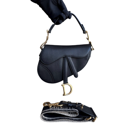 Sac Dior Saddle Small 21 cm en cuir caviar noir avec bandoulière et finitions dorées.